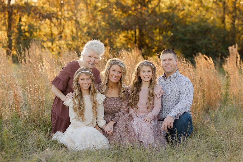 Family sitting together in a field for a photoshoot in Shreveport.